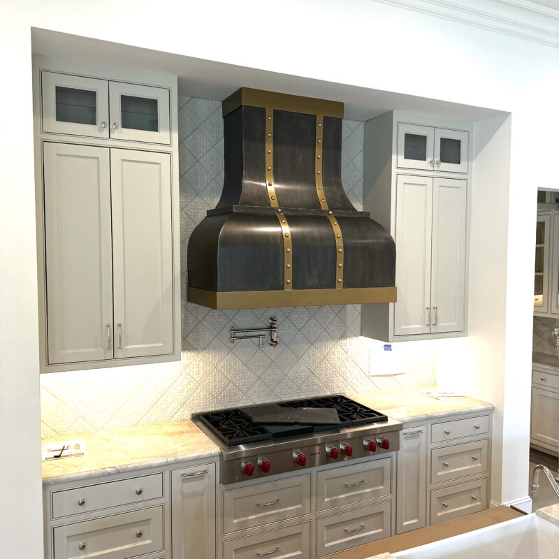 custom metal vent hood with brass trim